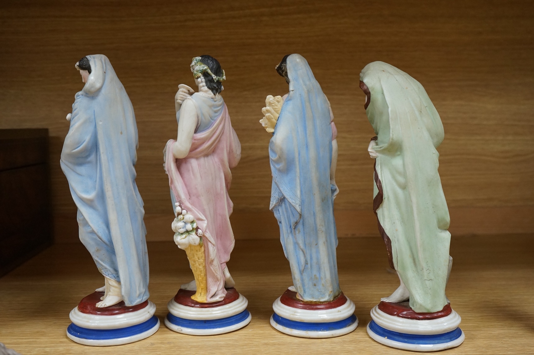 A set of four painted biscuit porcelain figures of The Seasons, and a silver-mounted scent bottle, figures 24cm